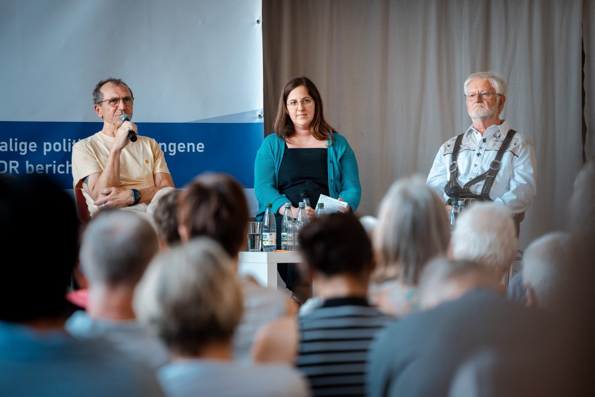 Das Foto zeigt eine öffentliche Gesprächsrunde mit zwei Zeitzeugen, die über ihre Hafterfahrungen und das Leben nach der Haft sprechen.